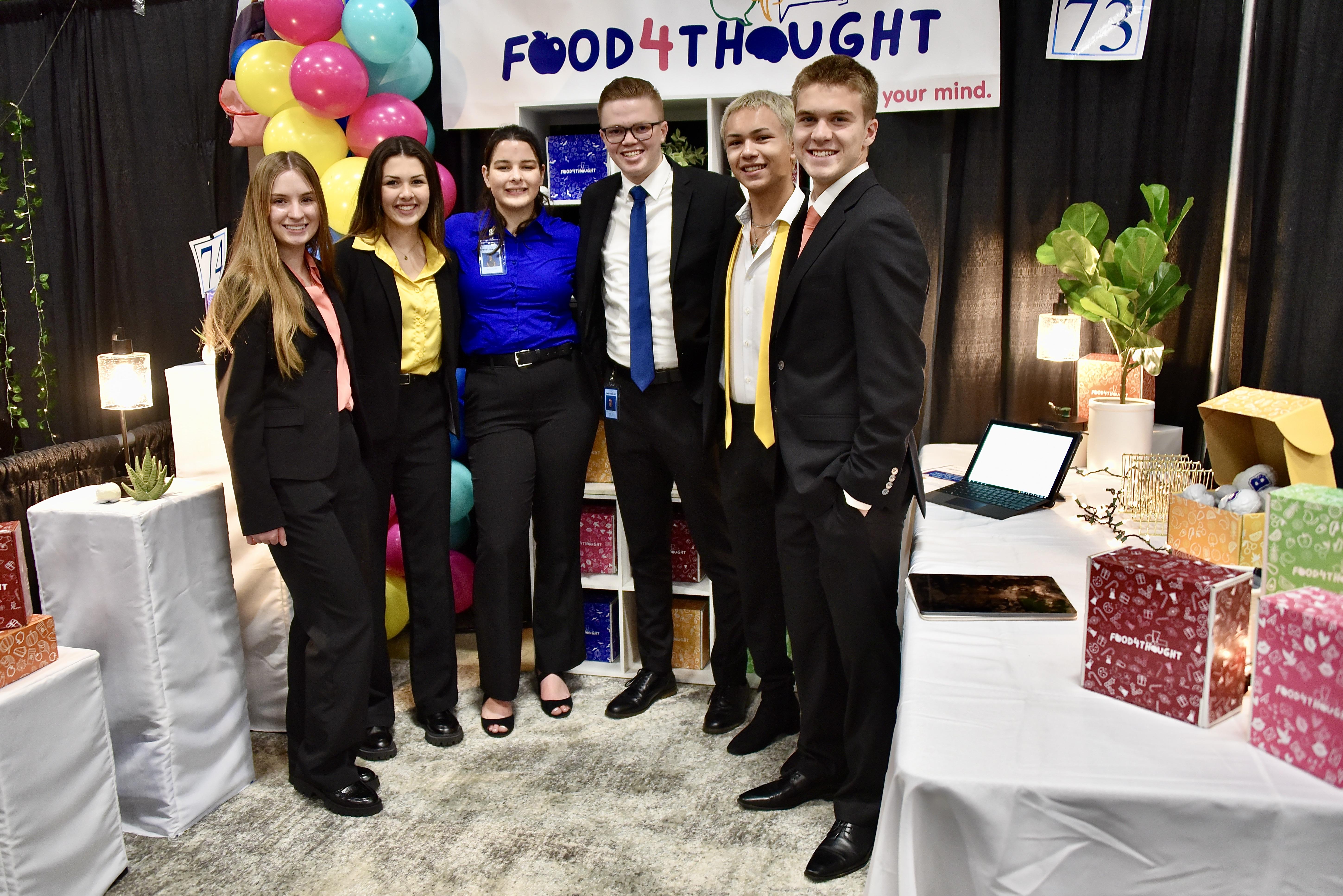Bakersfield High School's Business Plan Team, Food4Thought, posing for a photo in front of their booth